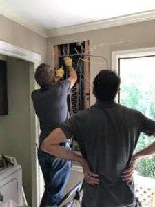 Technicians working indoors on an electrical panel upgrade in Colorado Springs, ensuring system safety and performance.